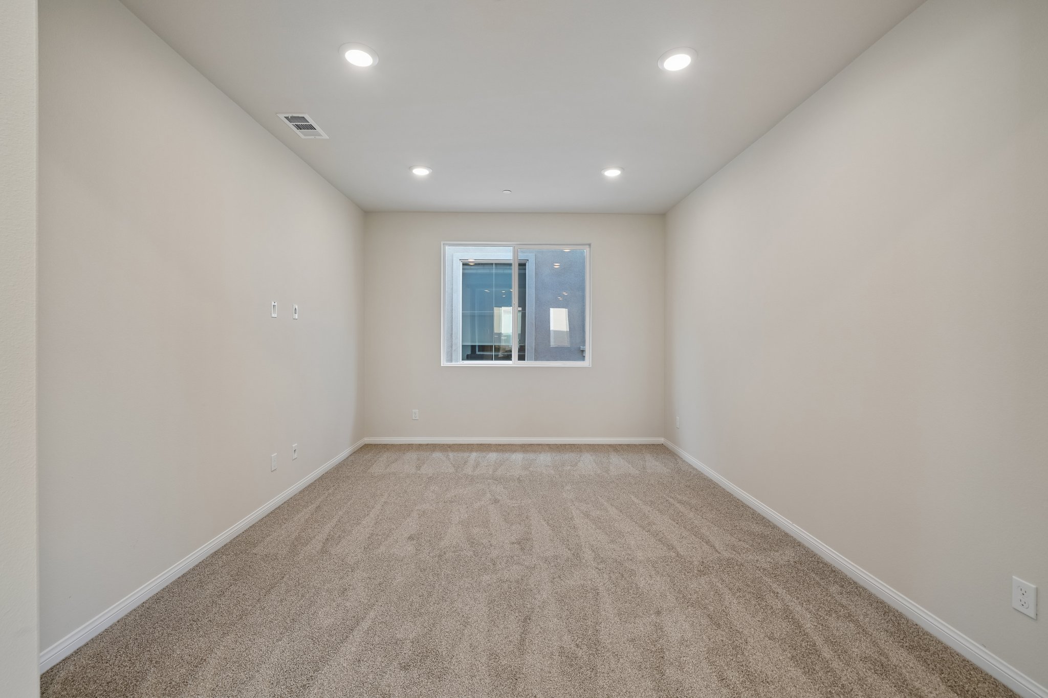 A room with a window and carpet.