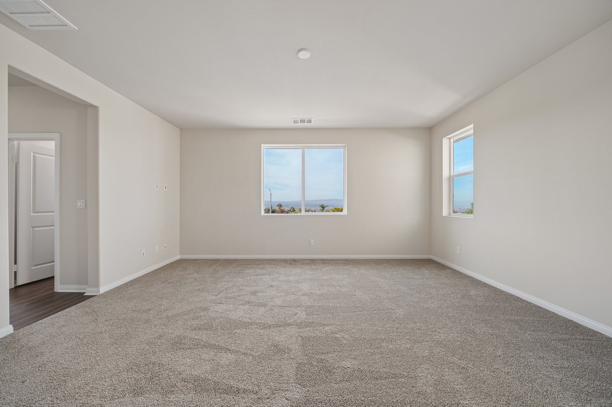 A room with a carpet and windows.