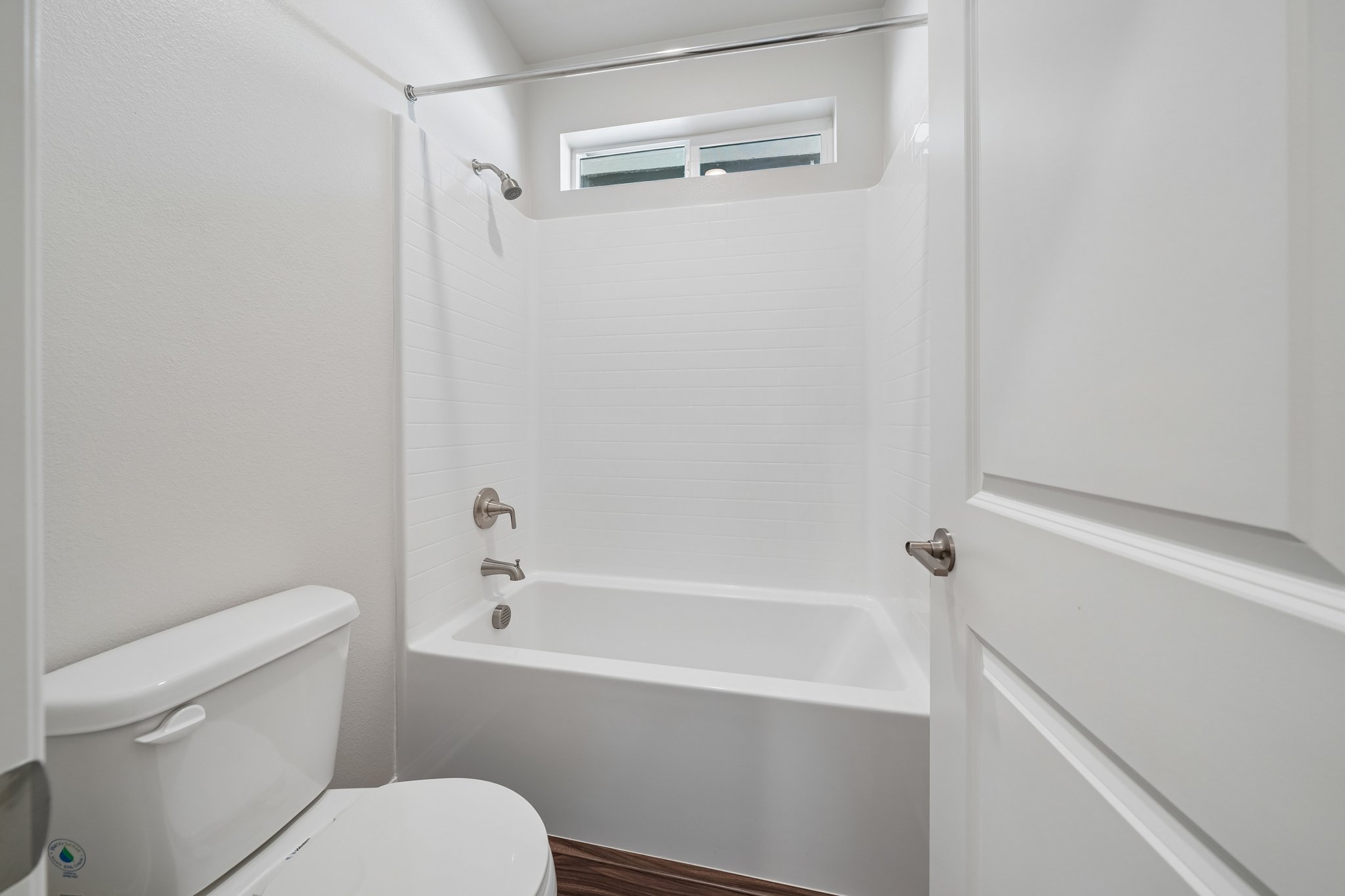 A bathroom with a toilet and bathtub.