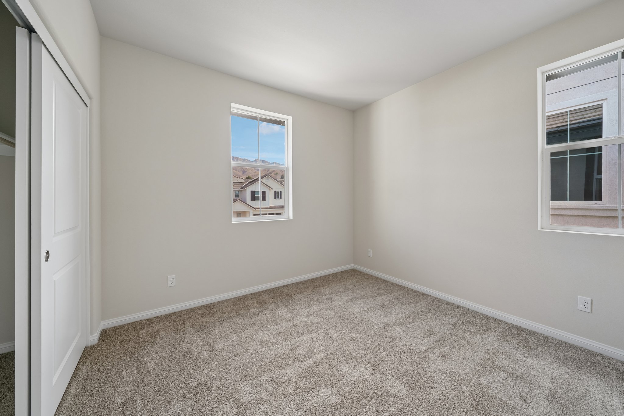 A room with a window and a carpet.