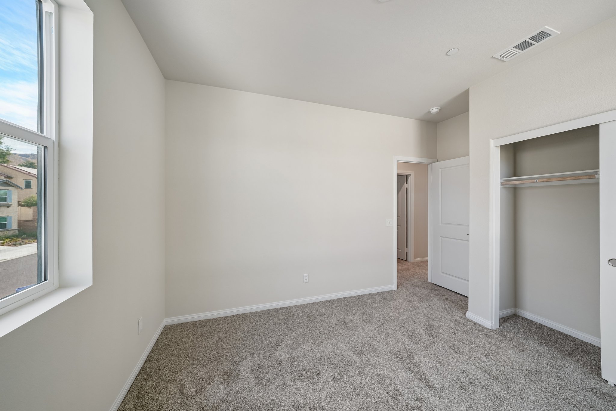 A room with a carpet and windows.