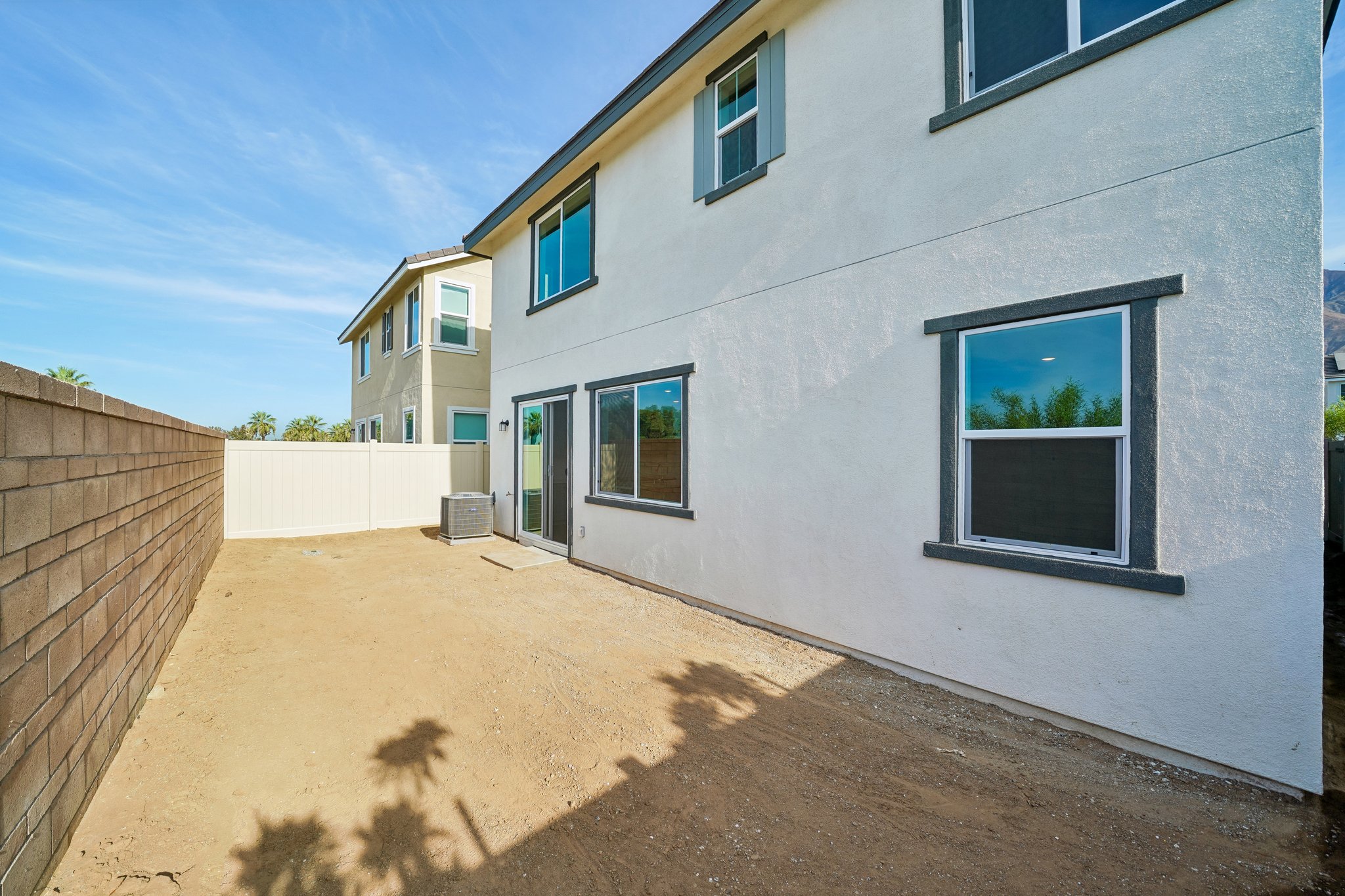 A building with windows and a dirt road.