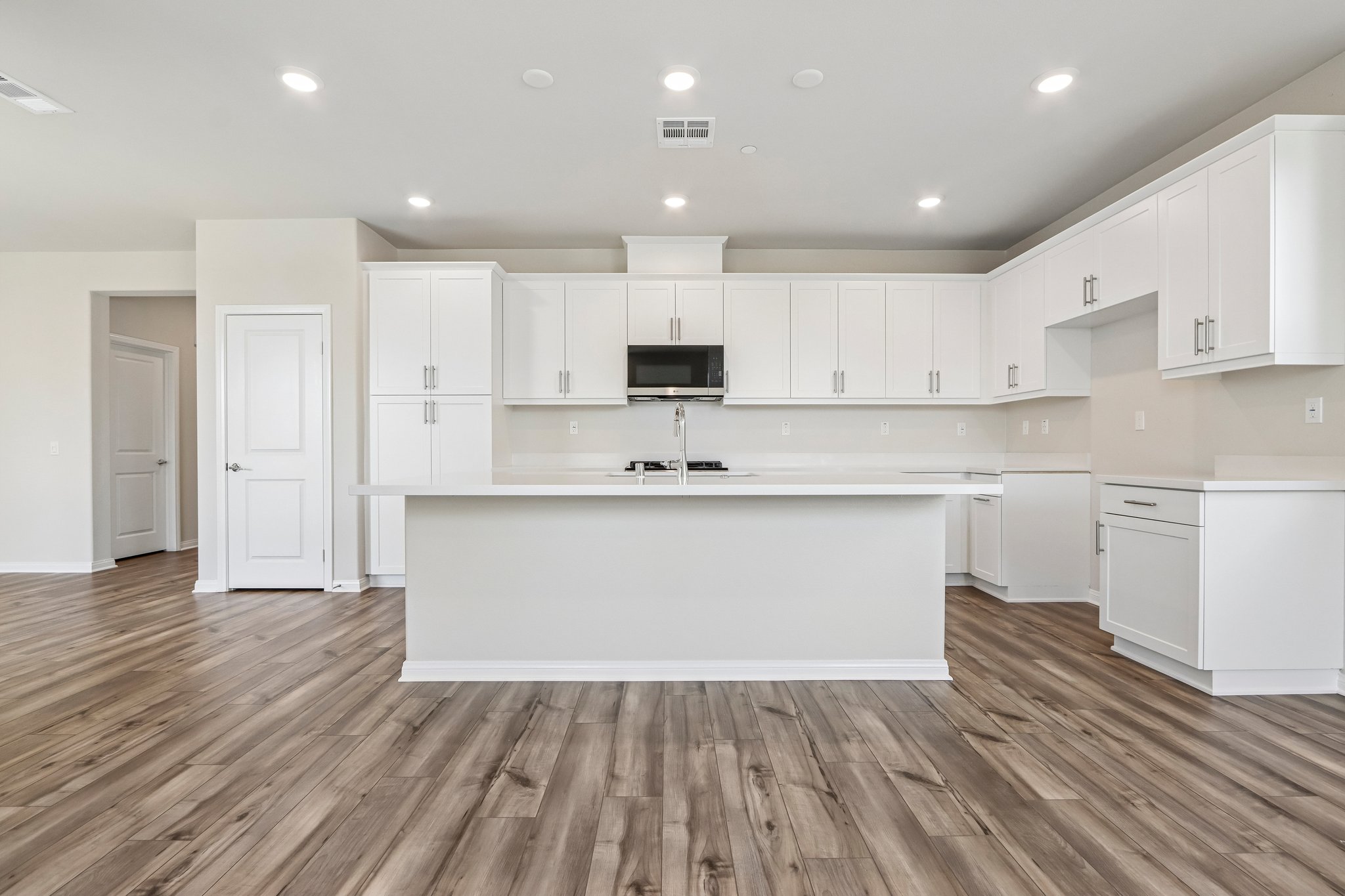 A kitchen with white cabinets.