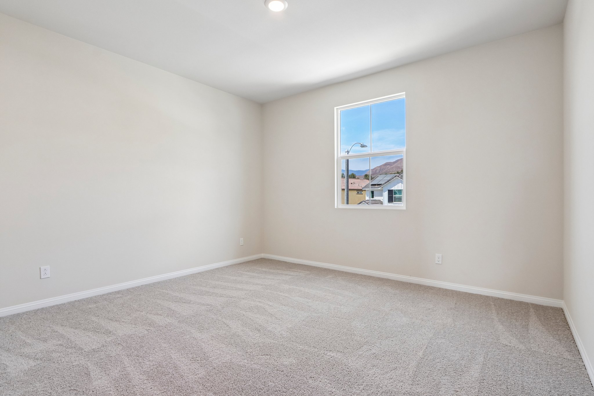 A room with a window and carpet.