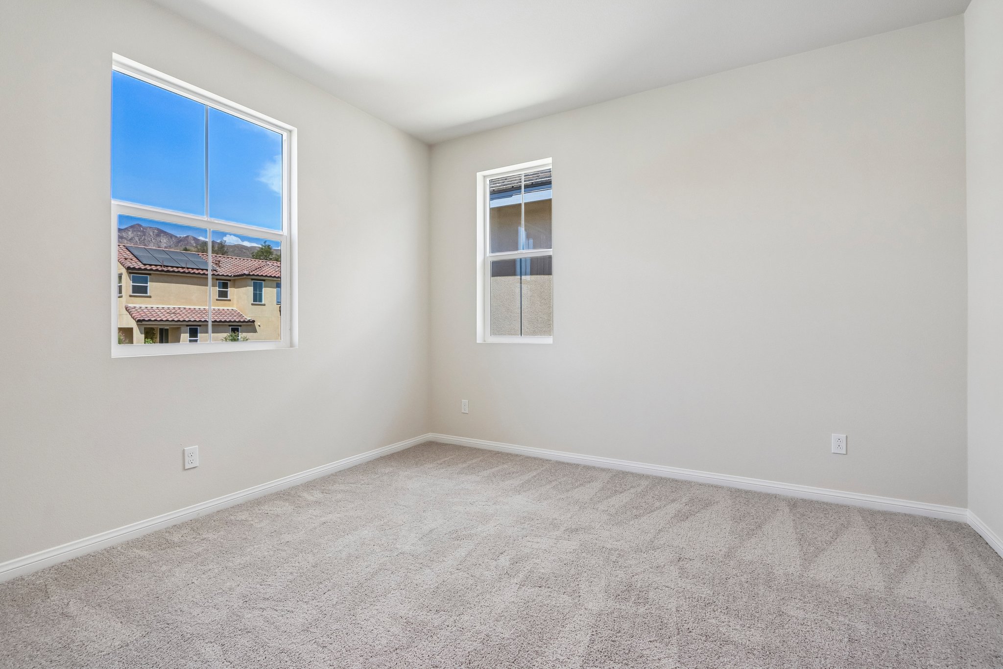 A room with a window and a rug.