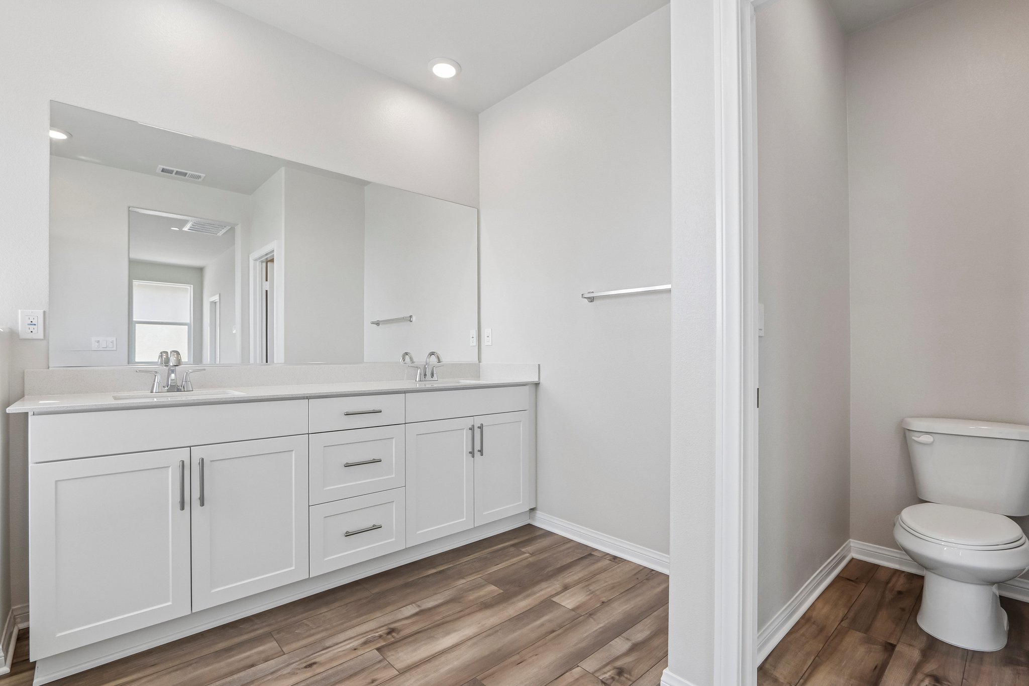 A bathroom with white cabinets.