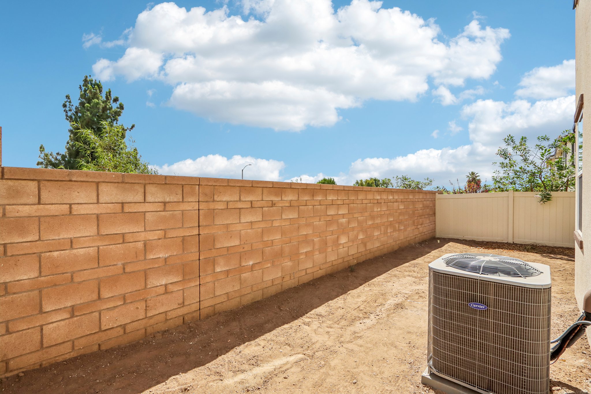A brick wall with a trash can.
