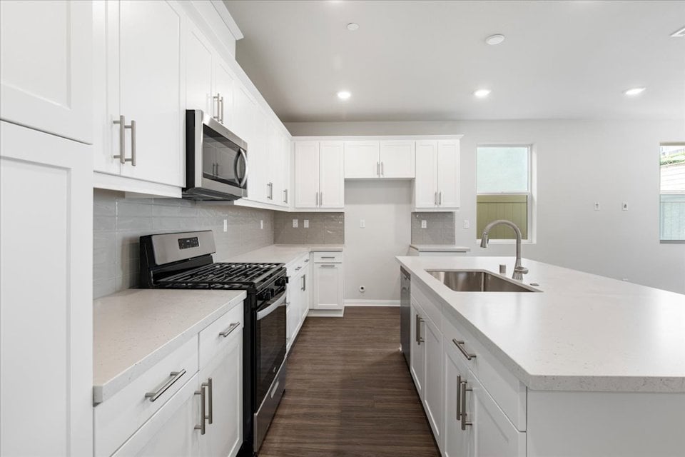 A kitchen with white cabinets.