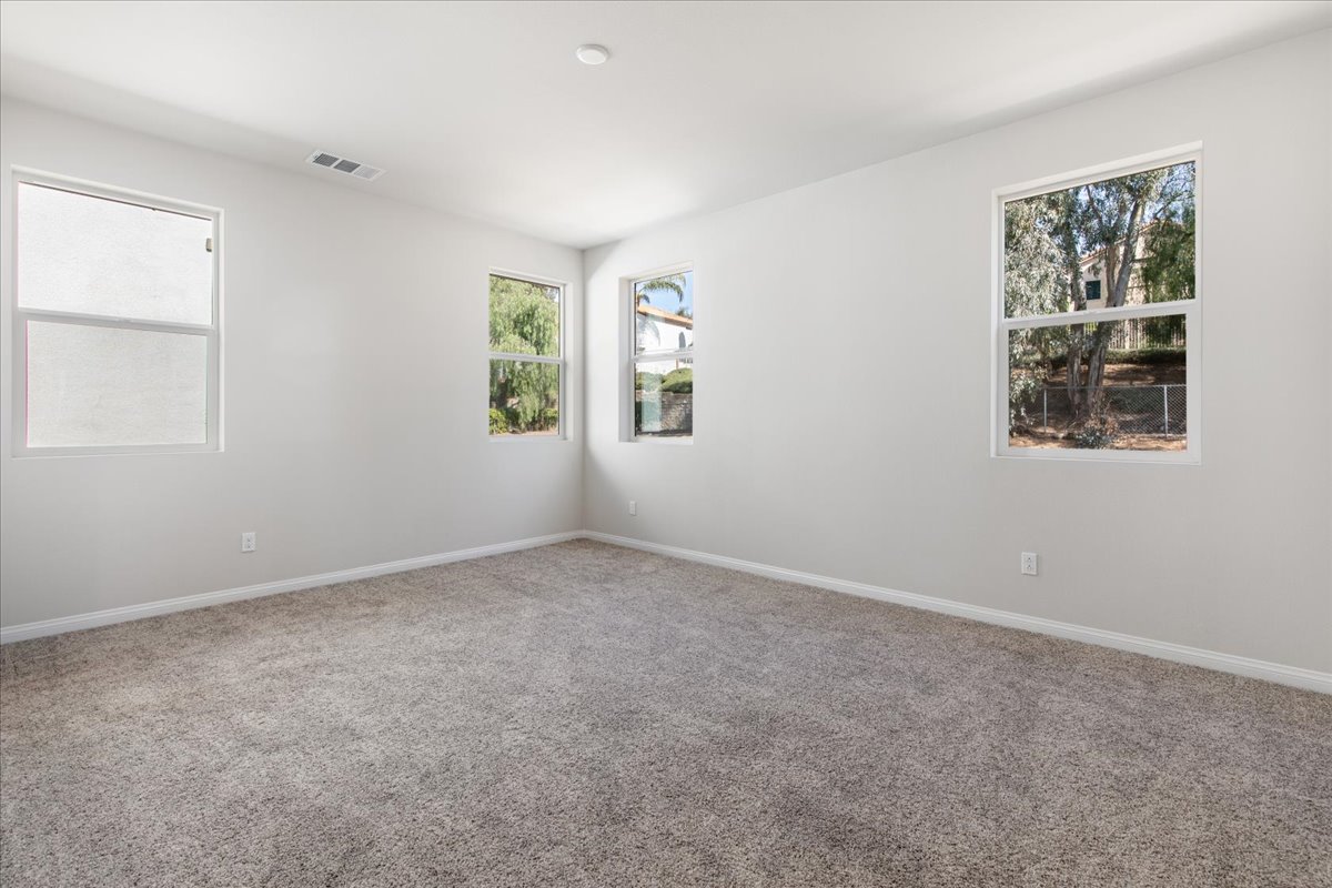 A room with a carpet and windows.