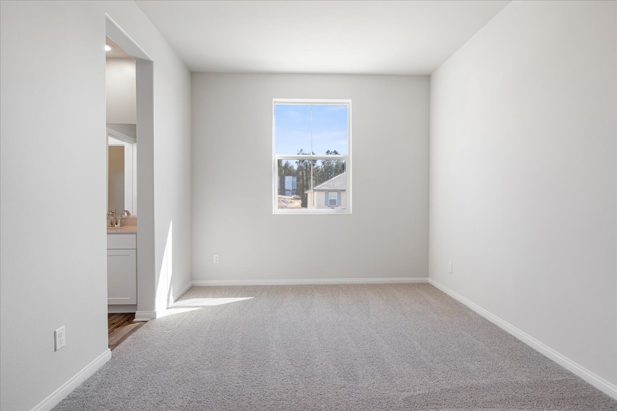 A room with a window and a white wall.