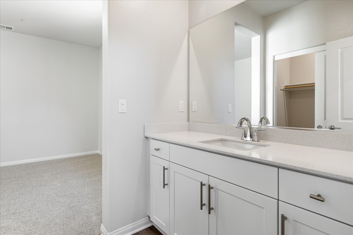 A bathroom with white cabinets.
