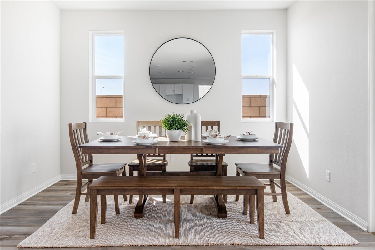 A dining table with chairs and a mirror.