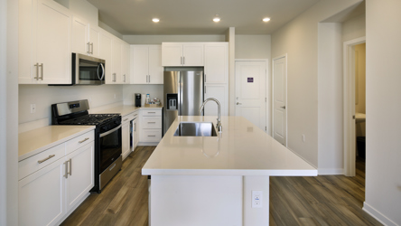 A kitchen with white cabinets.