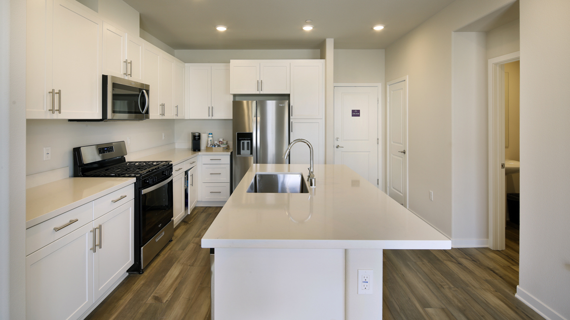 A kitchen with white cabinets.