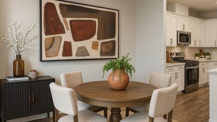 A dining room with a table and chairs.