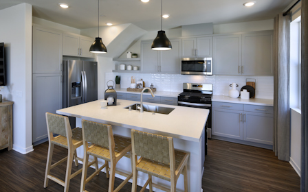 A kitchen with a table and chairs.