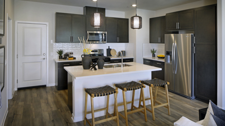 A kitchen with a bar and stools.