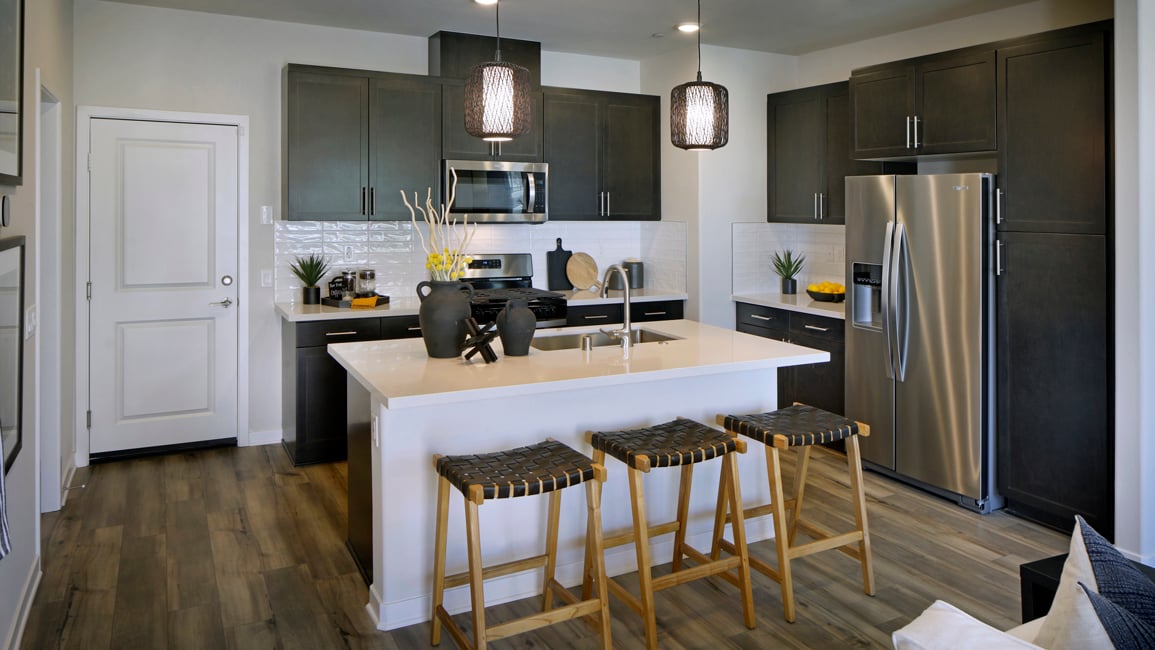A kitchen with a bar and stools.
