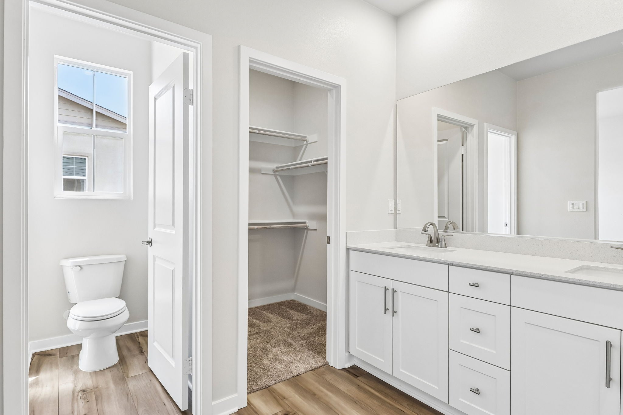 A bathroom with white cabinets.