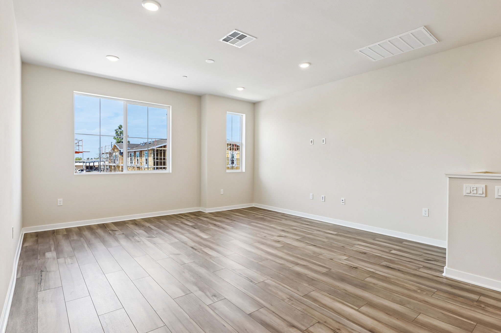 A room with a wood floor and a wood floor with a window.