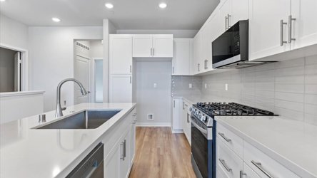 A kitchen with white cabinets.
