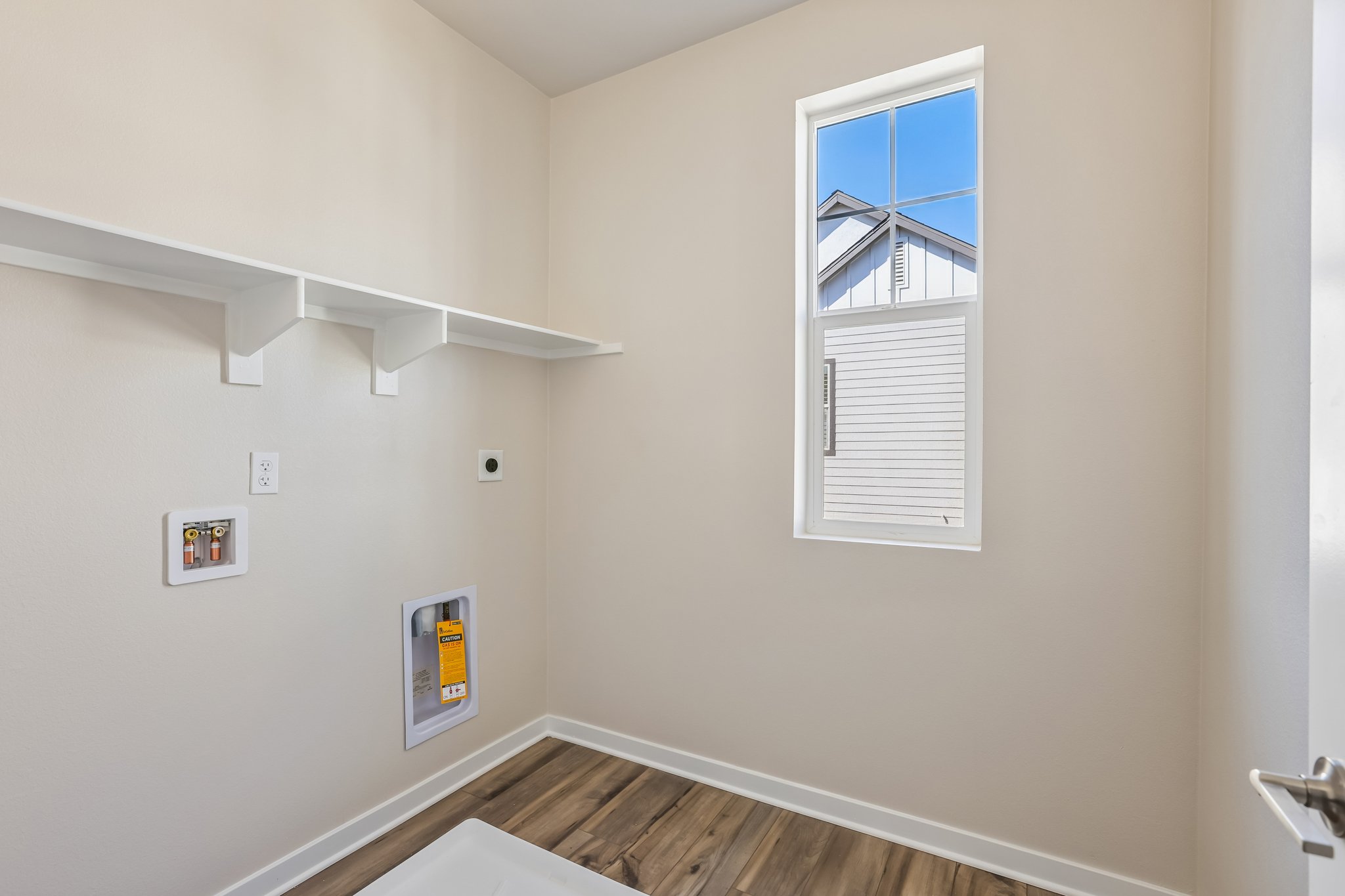 A room with a window and a wood floor.