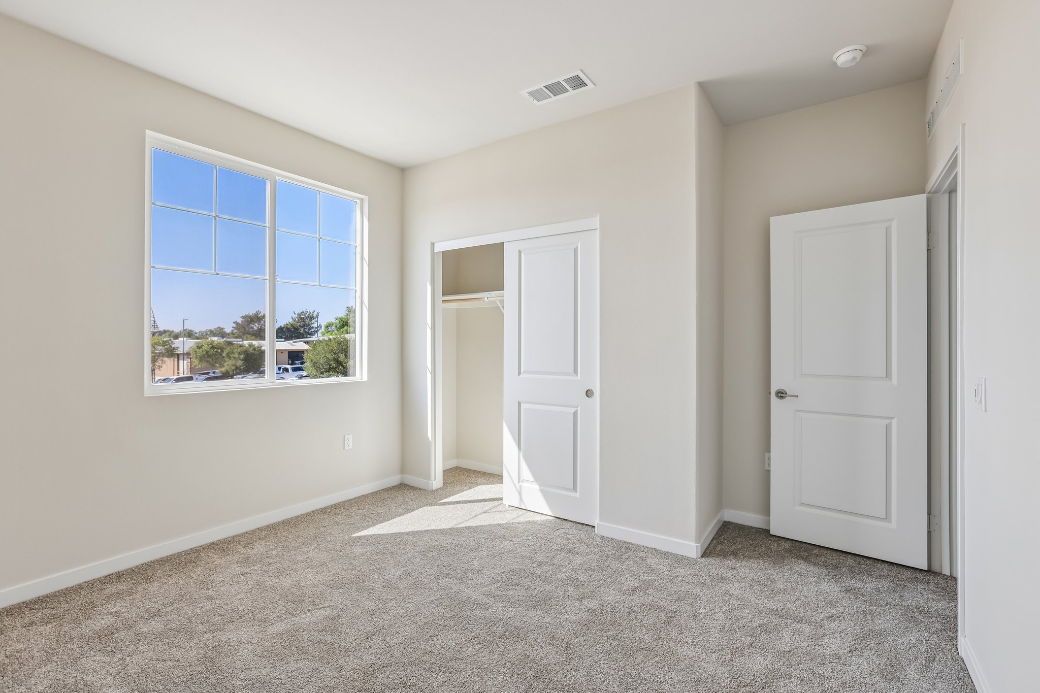 A room with white doors and a window.