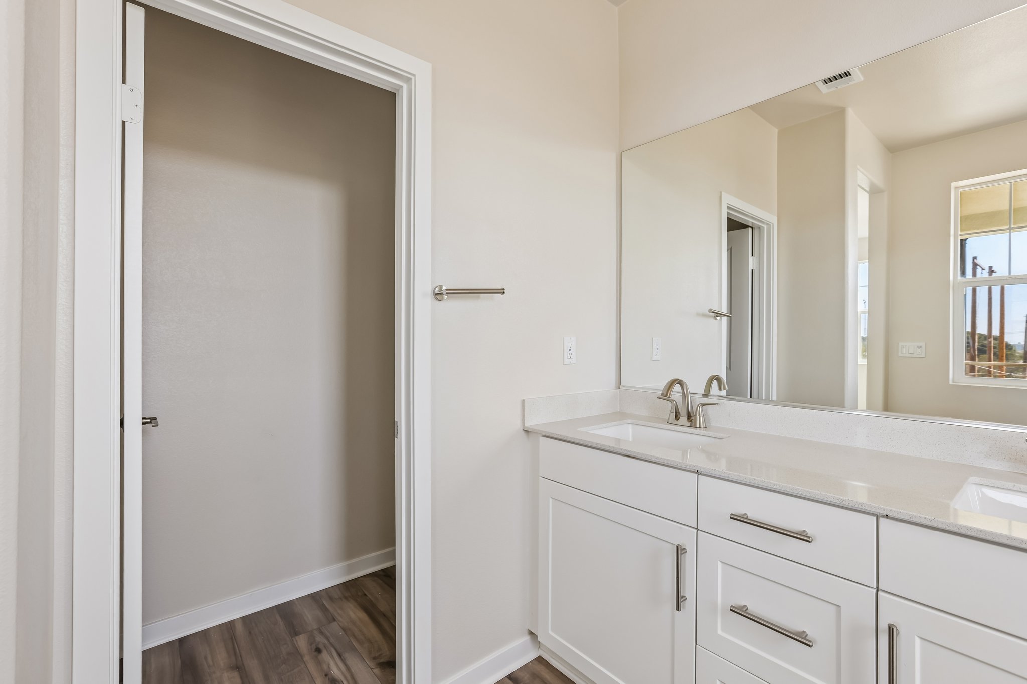 A bathroom with white cabinets.