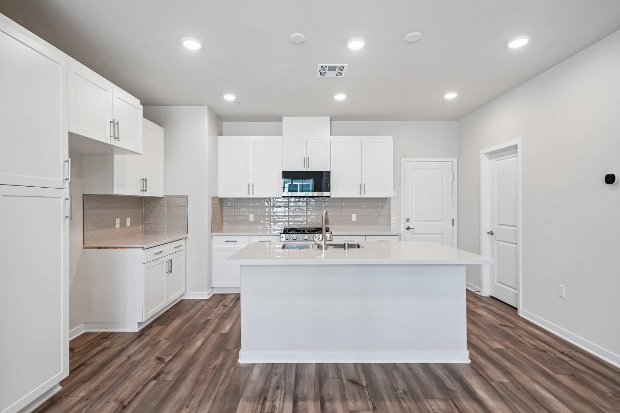A kitchen with white cabinets.