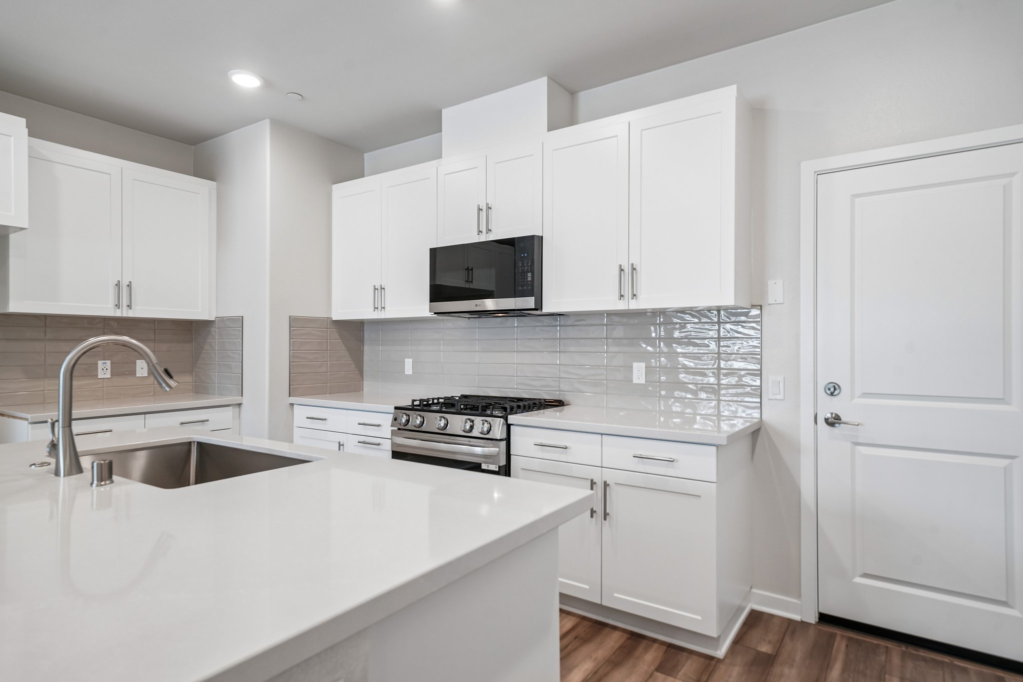 A kitchen with white cabinets.
