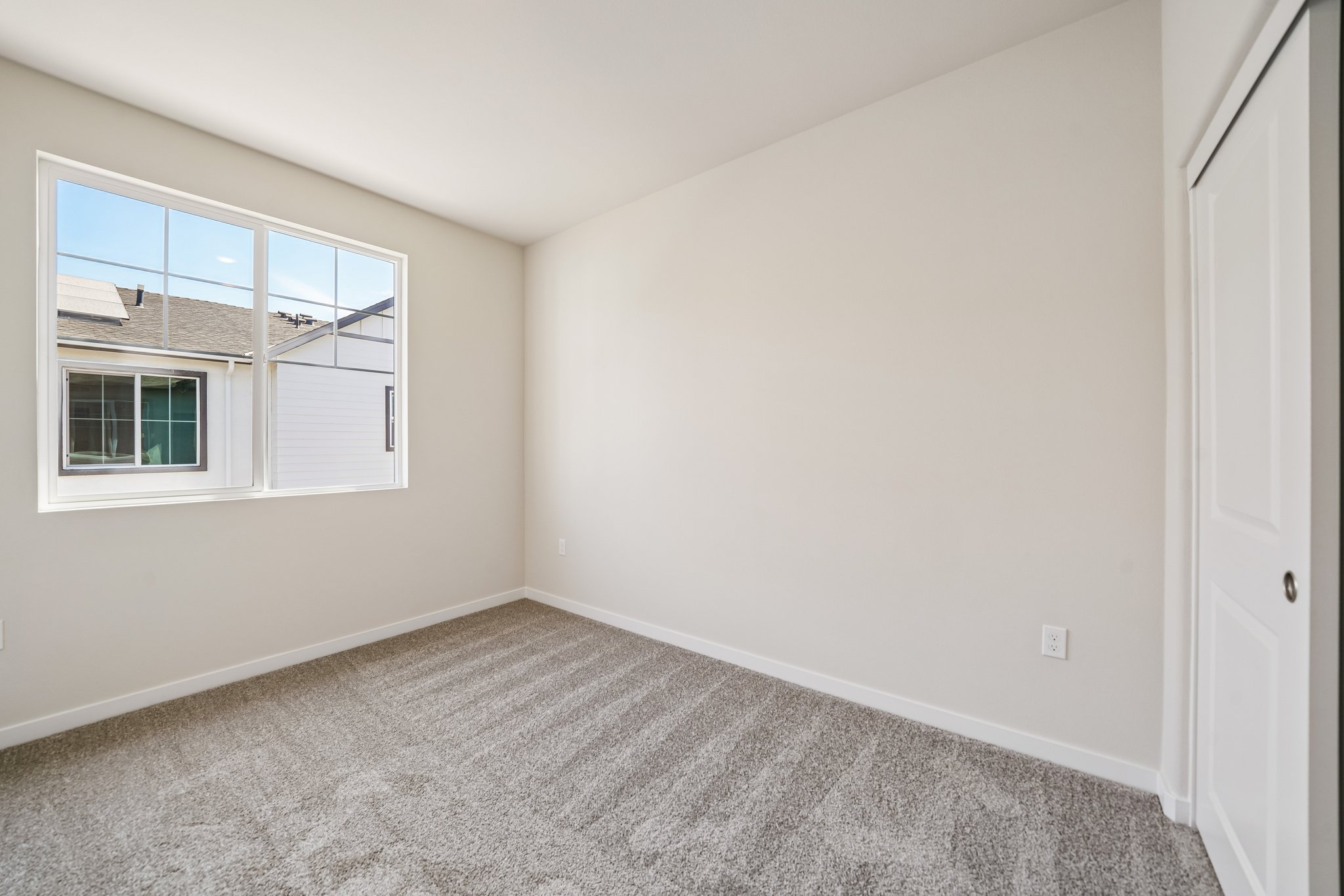 A room with a window and a carpet.