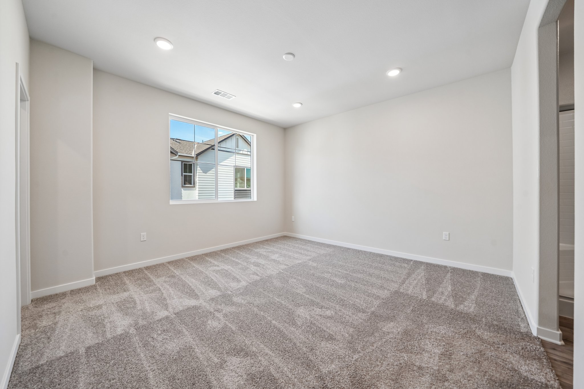 A room with a carpet and a window.