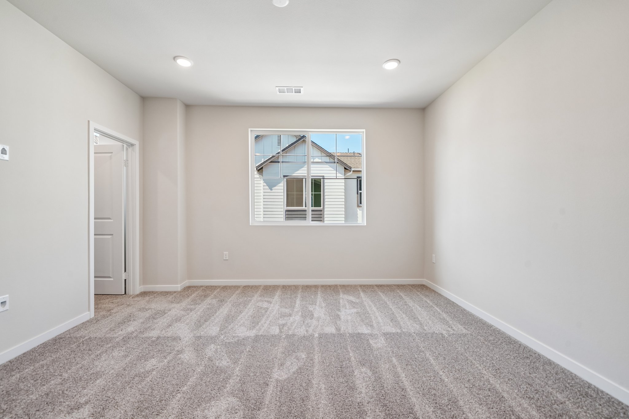 A room with a window and a rug.