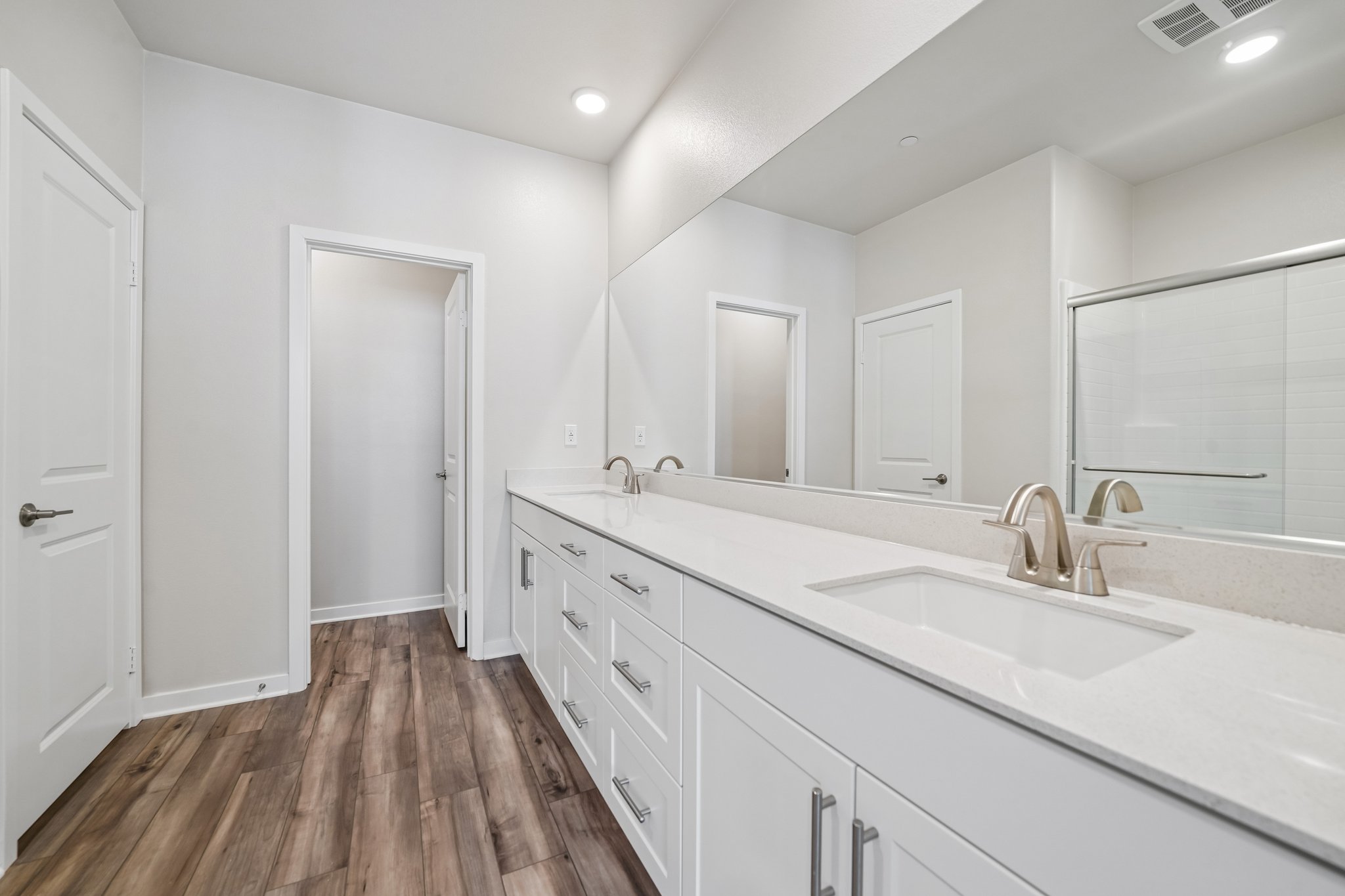 A bathroom with white cabinets.