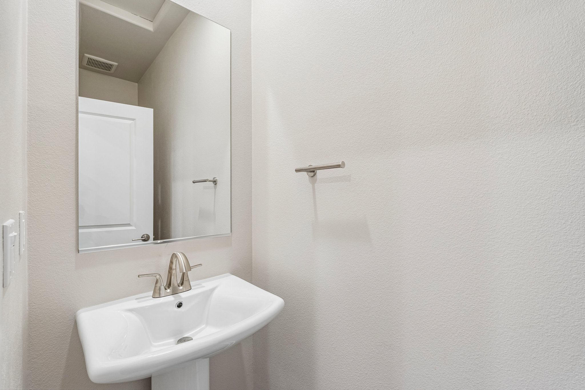 A bathroom with a mirror and sink.