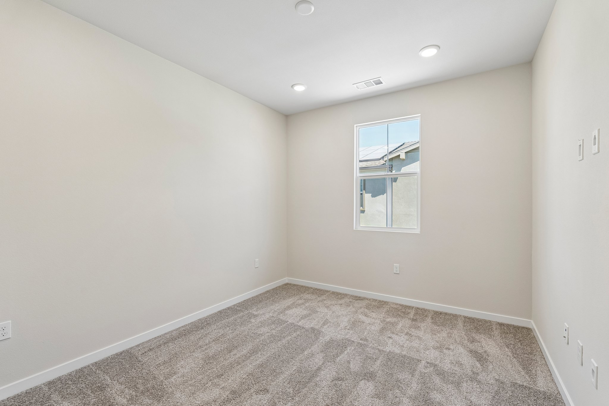 A room with a window and a carpet.