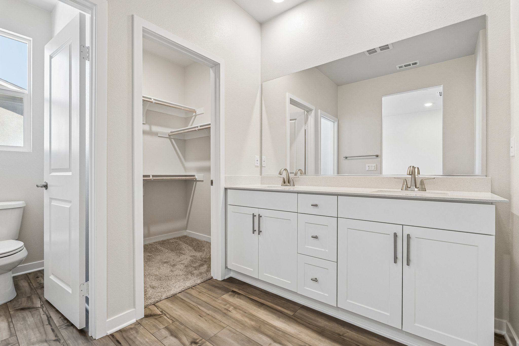 A bathroom with white cabinets.