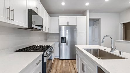 A kitchen with white cabinets.