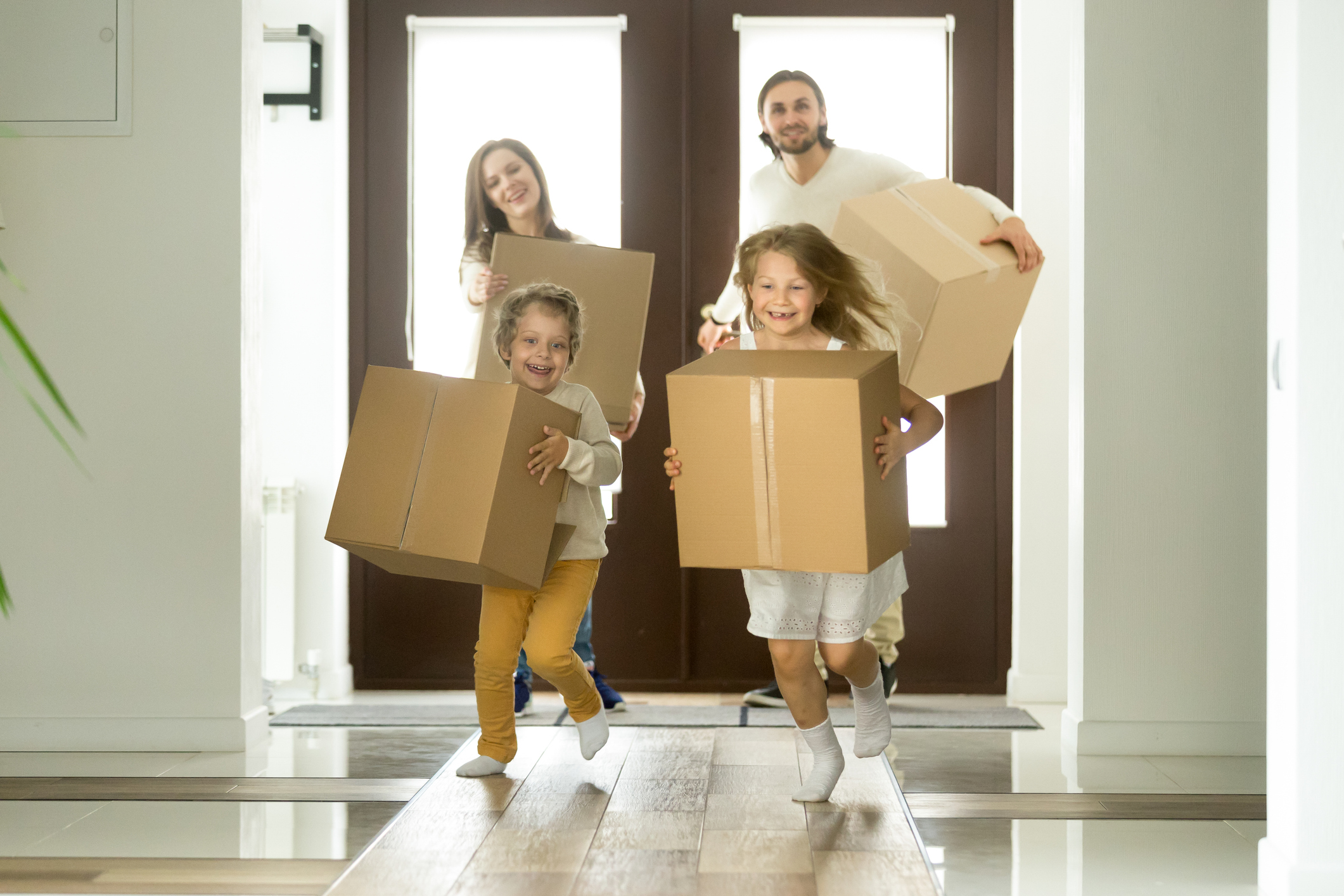 A group of children carrying boxes.