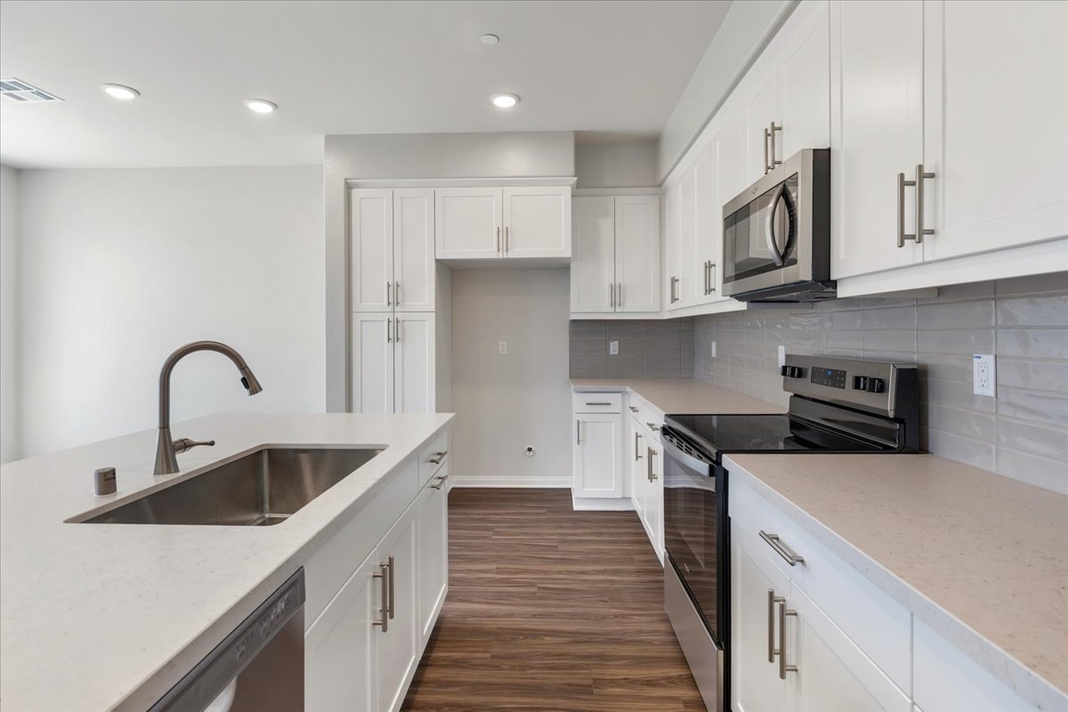 A kitchen with white cabinets.