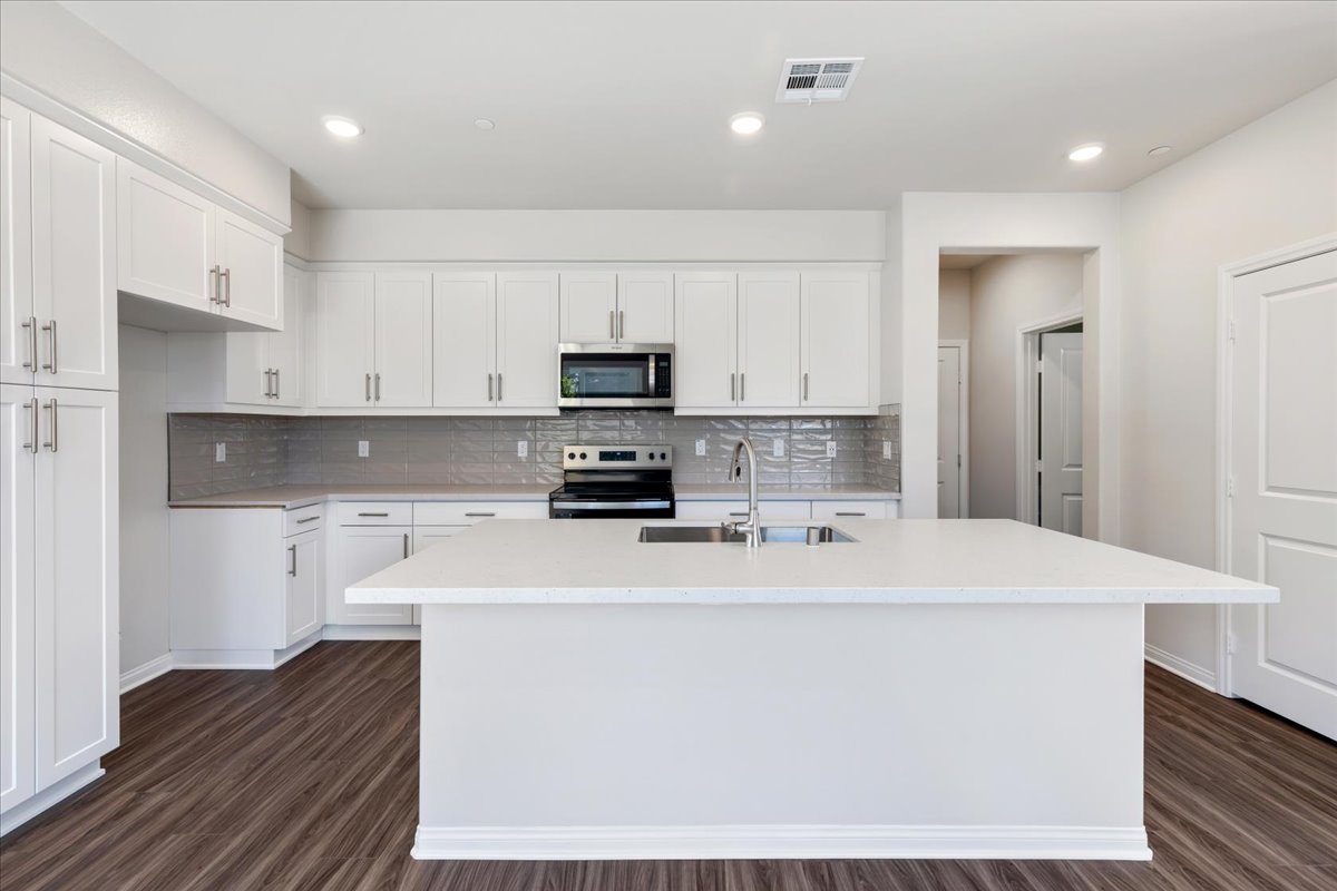 A kitchen with white cabinets.