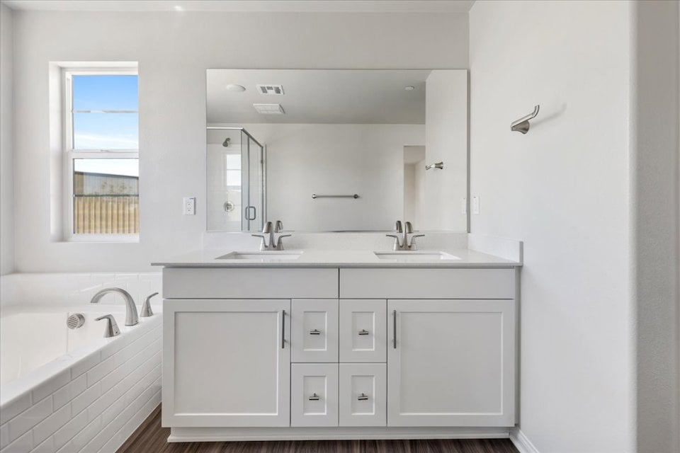A bathroom with a tub sink and mirror.