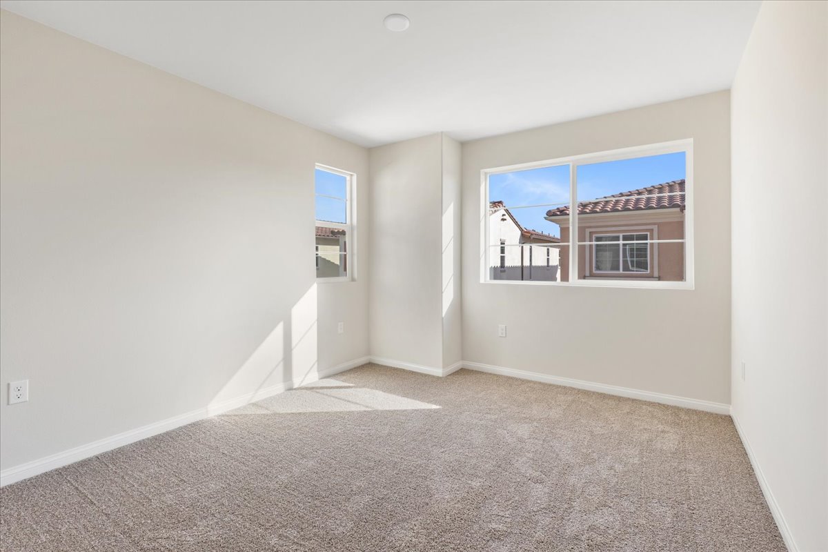A room with a carpet and windows.