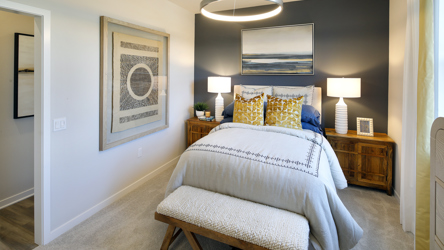 A bedroom with a bed and lamps.