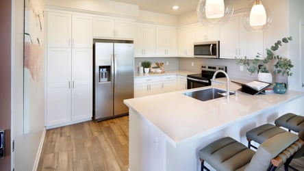 A kitchen with white cabinets.