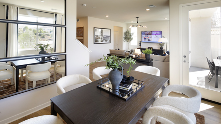 A living room with a large table and chairs.