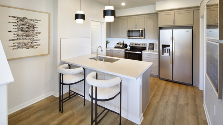 A kitchen with a table and chairs.