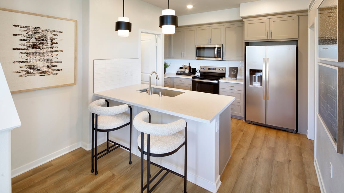 A kitchen with a table and chairs.