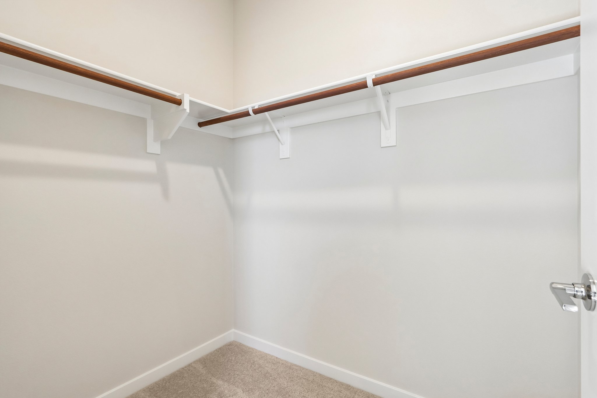 A white wall with a metal bar.