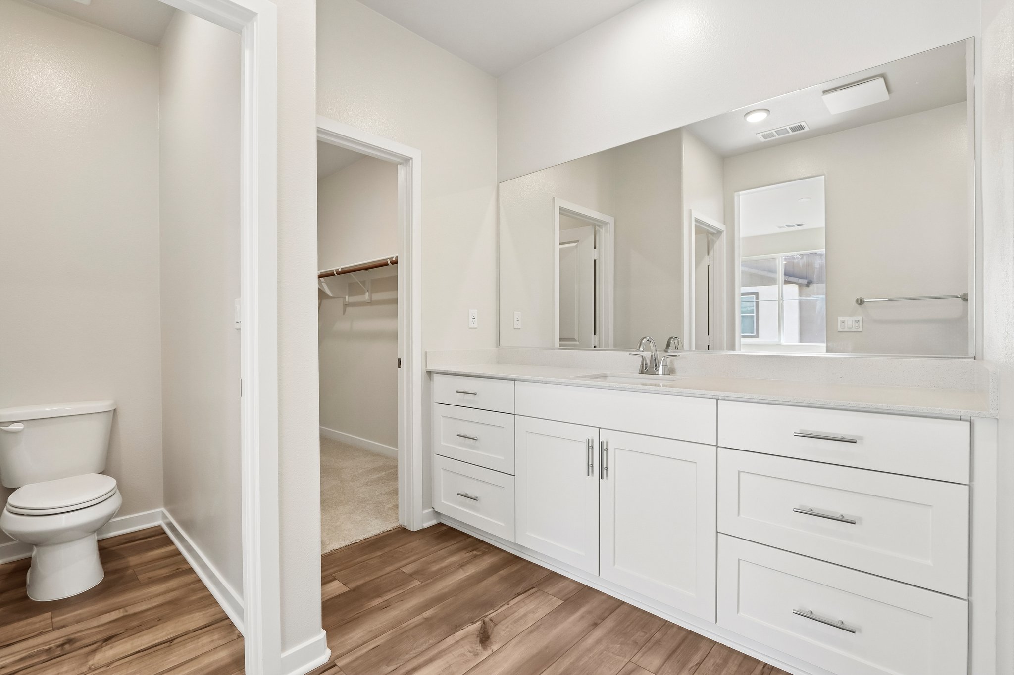A bathroom with white cabinets.